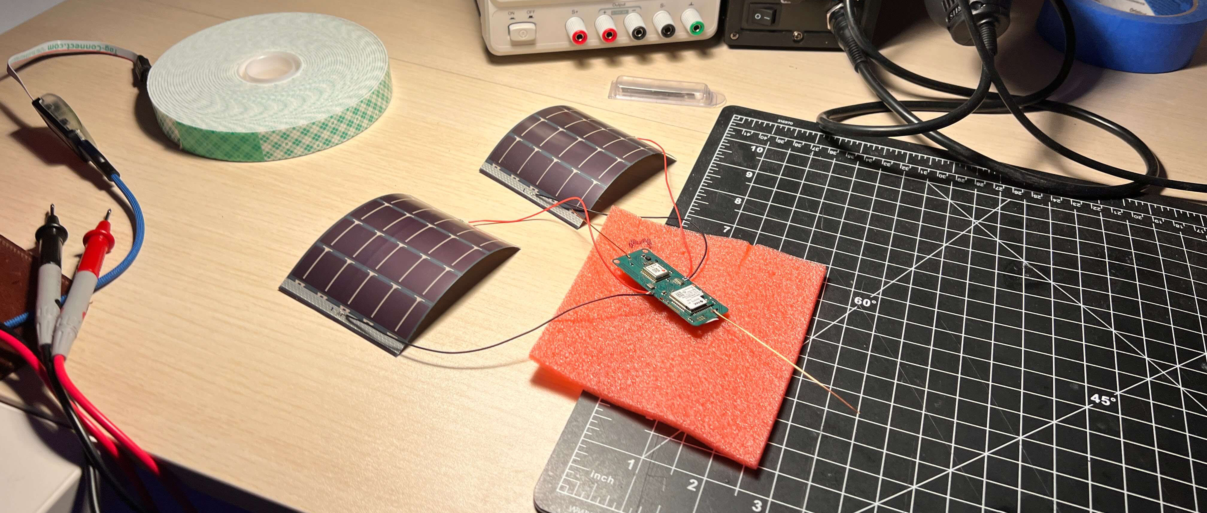 An early Stratolink board connected to its two flexible solar panels on the bench.